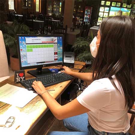Cajera revisando el mapa de mesas.